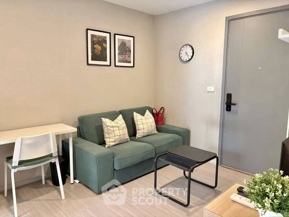 Cozy living room with green sofa, modern decor, and wall art in a stylish apartment.