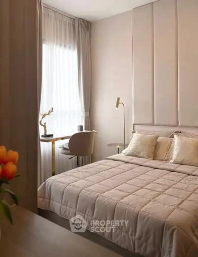 Elegant bedroom with modern decor and natural light, featuring a cozy bed and stylish workspace.