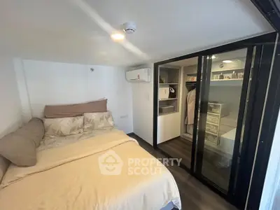 Cozy bedroom with walk-in closet and modern design in a compact space.