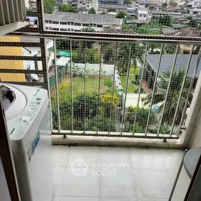 High-rise balcony with washing machine and city view, perfect for urban living.