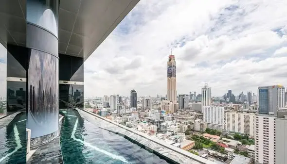 Stunning rooftop pool with panoramic city skyline view in luxury high-rise building.