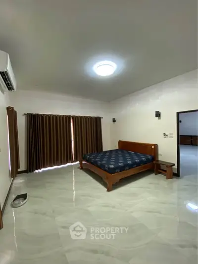 Spacious bedroom with modern design and large windows for natural light.