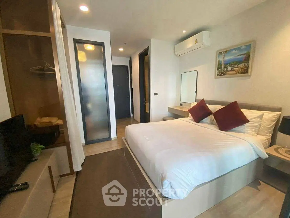 Modern bedroom with cozy bed, stylish decor, and ample storage in a contemporary apartment.