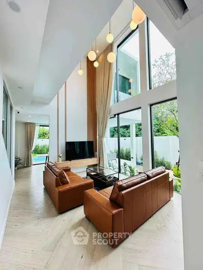 Luxurious modern living room with high ceilings and large windows overlooking garden