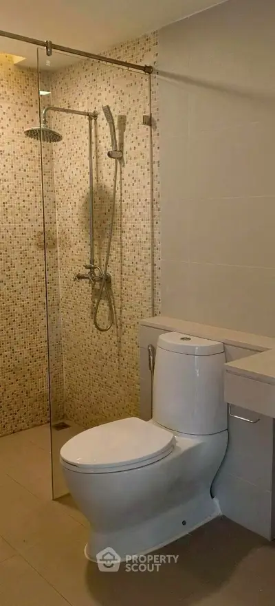 Modern bathroom with glass shower and sleek toilet design.