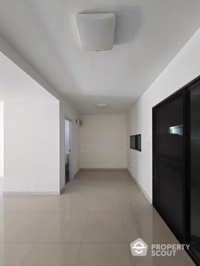 Spacious modern hallway with sleek tile flooring and minimalist design