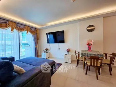 Spacious living room with modern decor and large TV, perfect for relaxation and entertainment.