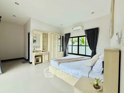 Spacious modern bedroom with large window and elegant furnishings
