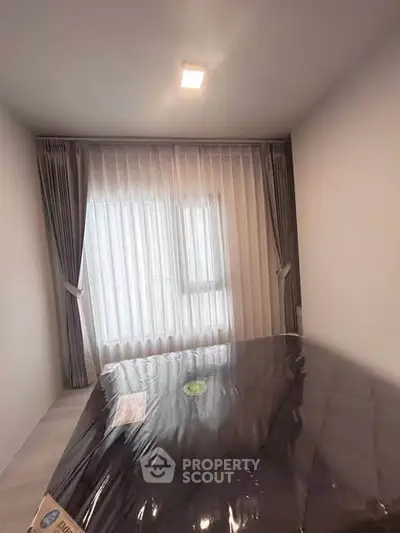 Cozy bedroom with large window and elegant curtains, perfect for natural light lovers.