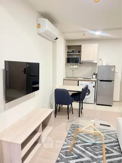 Modern living room with open kitchen, featuring sleek appliances and stylish furniture in a cozy apartment.