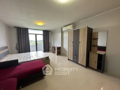 Spacious modern bedroom with large window and stylish furniture