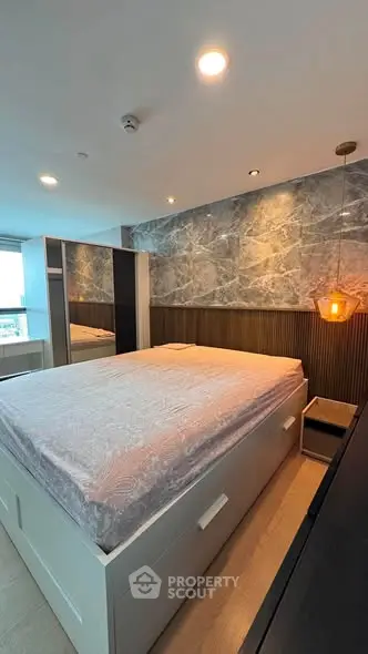 Luxurious bedroom with modern design and elegant lighting, featuring a stylish bed and marble accent wall.