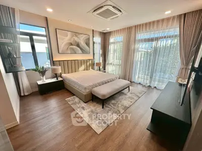 Luxurious bedroom with large windows and modern decor, featuring elegant lighting and stylish furnishings.
