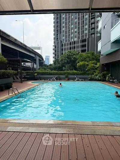 Luxurious urban apartment complex with a stunning outdoor pool and city views.