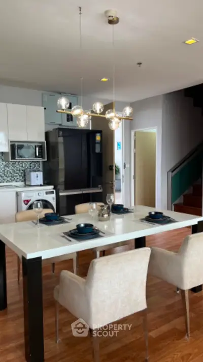 Modern dining area with elegant table setting and stylish lighting in open-plan kitchen