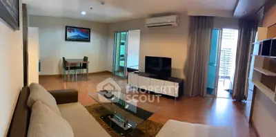 Spacious modern living room with glass coffee table and balcony access