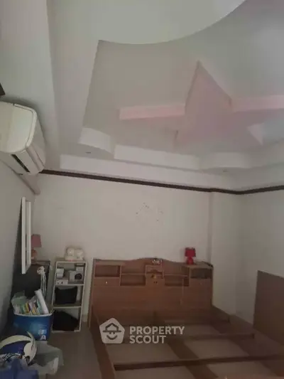 Spacious bedroom with unique ceiling design and ample storage space.