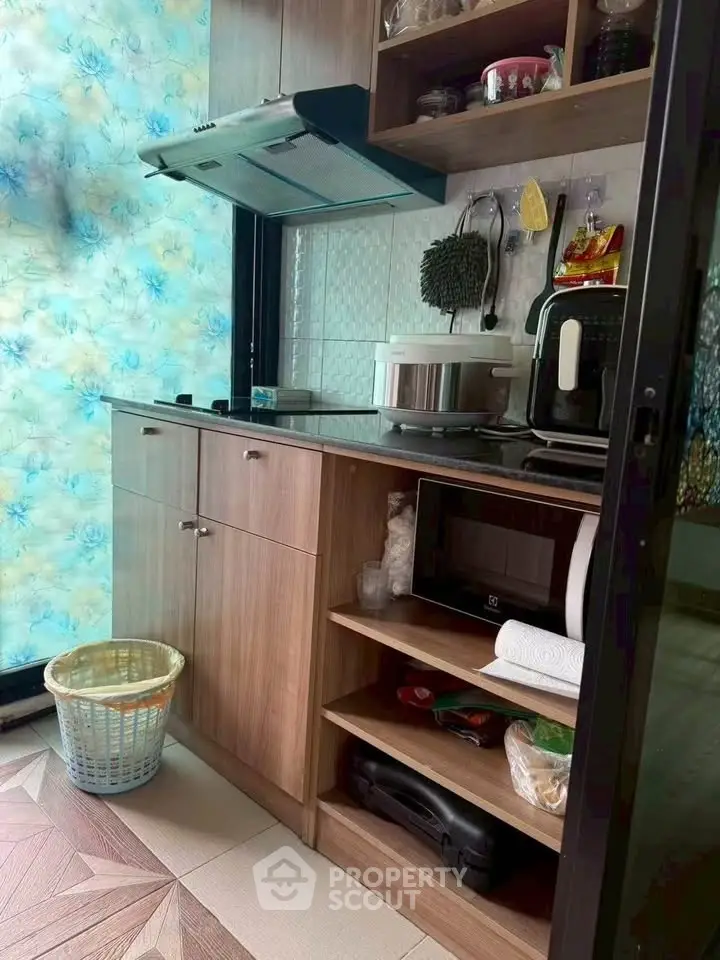 Compact kitchen with modern appliances and wooden cabinetry