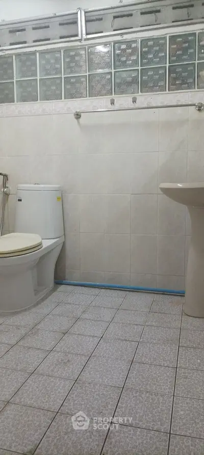 Spacious bathroom with modern fixtures and tiled walls, ideal for comfort and functionality.
