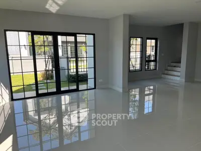Spacious modern living room with large windows and glossy tiled floors in a contemporary home.