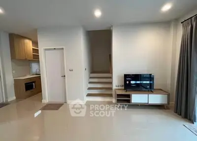 Modern living room with sleek design and integrated kitchen area