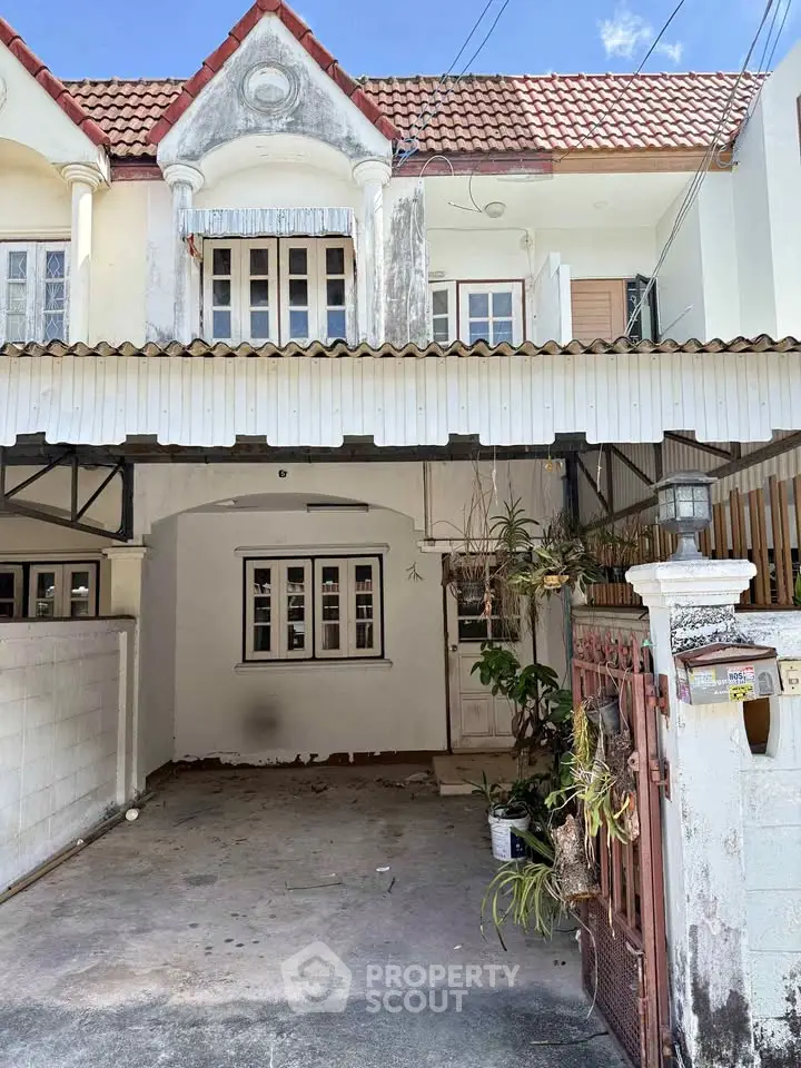 Charming townhouse with unique architectural details and spacious driveway, perfect for renovation enthusiasts.