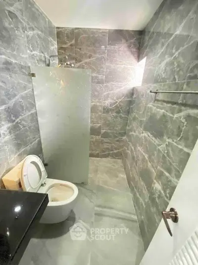 Modern bathroom with marble tiles and glass shower partition