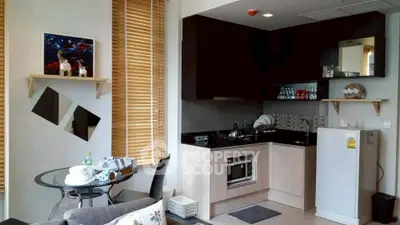 Modern kitchen with sleek design and compact dining area, featuring wooden blinds and stylish decor.