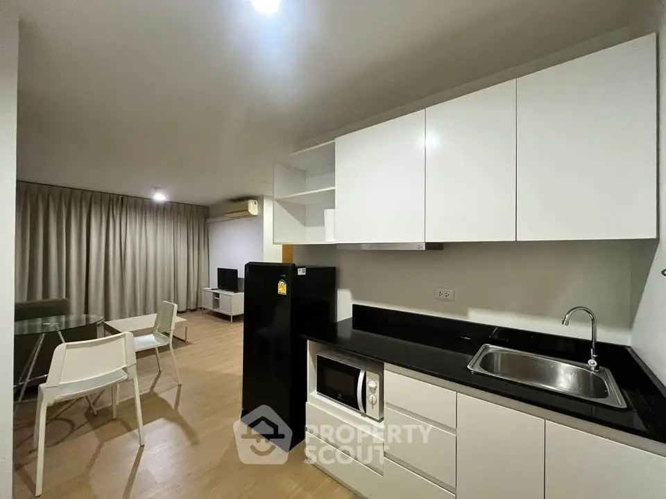 Modern open-plan kitchen and living area with sleek design and ample lighting.