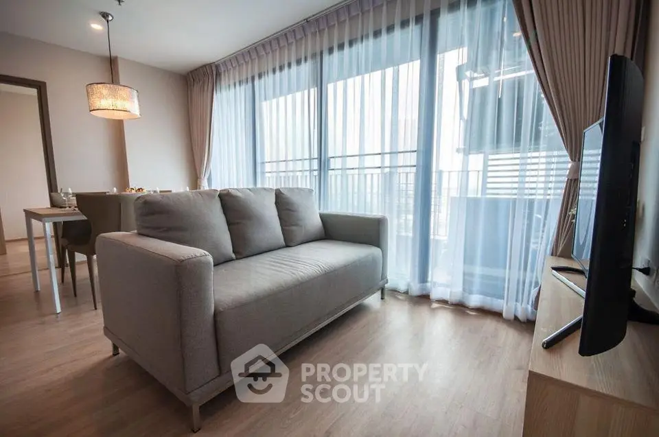 Modern living room with large windows and stylish furniture in a contemporary apartment.