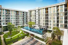 Modern apartment complex with pool and landscaped garden view.
