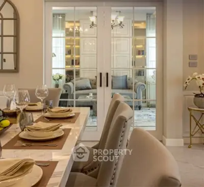 Elegant dining area with a view into a cozy living room, featuring stylish decor and comfortable seating.