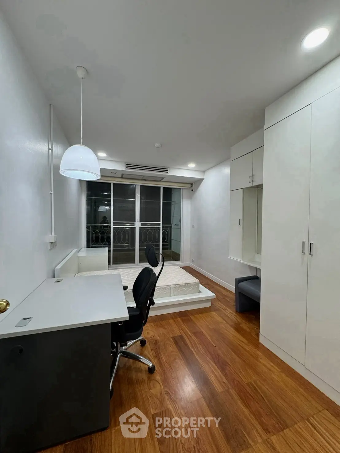 Modern study room with sleek desk, ergonomic chair, and large window for natural light.