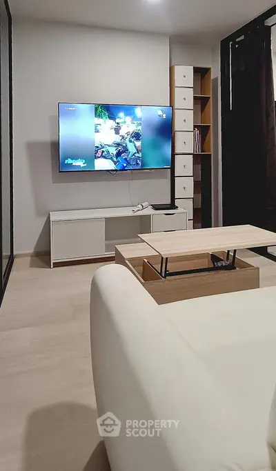 Modern living room with sleek furniture and wall-mounted TV, perfect for cozy relaxation.