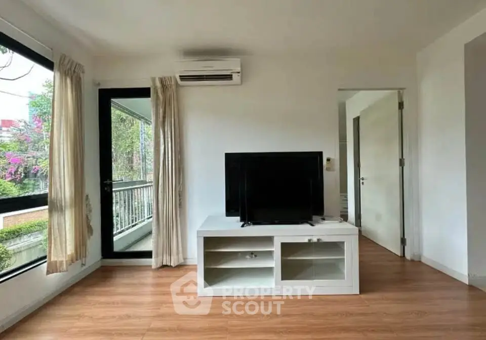 Spacious living room with modern decor and large windows offering natural light.