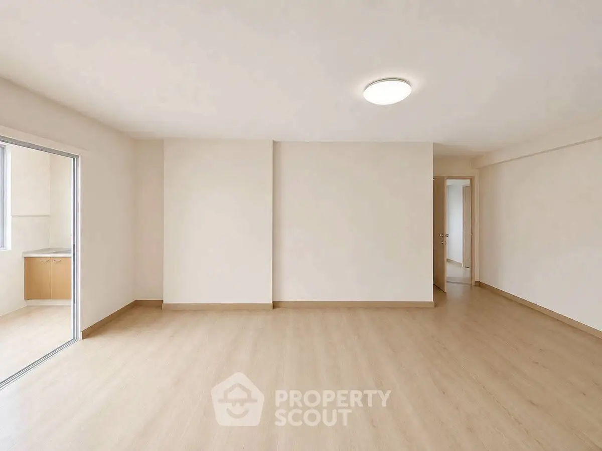 Spacious empty living room with wooden flooring and natural light