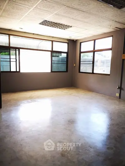 Spacious empty room with large windows and natural light