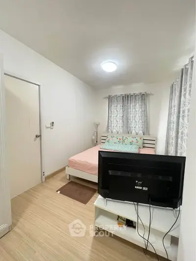 Cozy bedroom with modern decor and natural light, featuring a comfortable bed and stylish curtains.