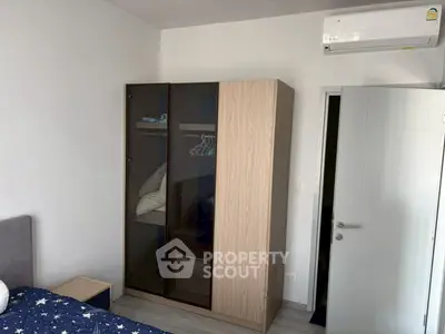 Modern bedroom with sleek wardrobe and air conditioning unit