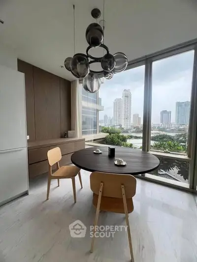 Modern dining area with city view, featuring stylish round table and contemporary lighting.
