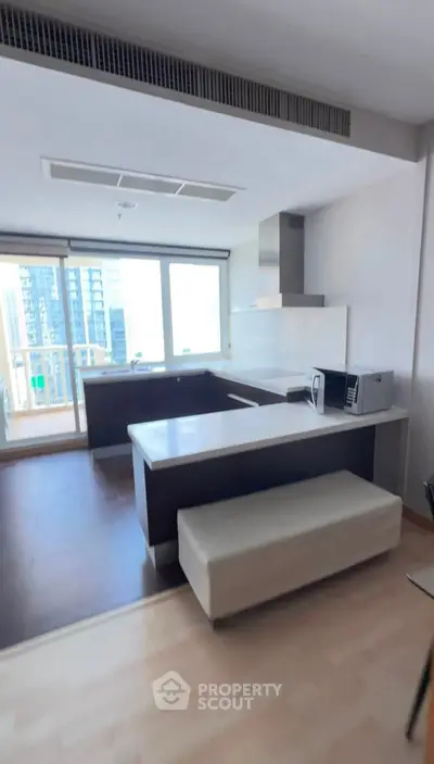 Modern kitchen with open layout and city view, featuring sleek countertops and built-in appliances.