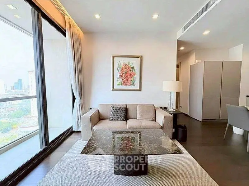 Modern living room with large windows and city view, featuring elegant decor and comfortable seating.
