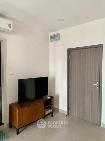 Modern living room with sleek TV stand and air conditioning unit, perfect for cozy relaxation.