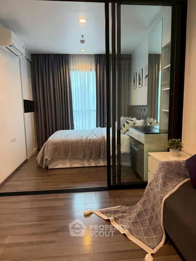 Modern bedroom with glass sliding doors and elegant decor in a stylish apartment.