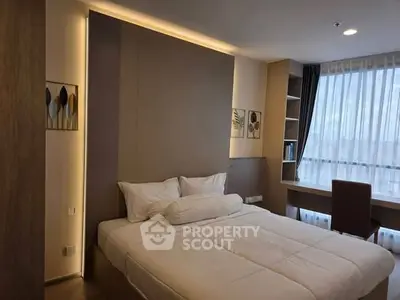 Modern bedroom with cozy bed and natural light from large window