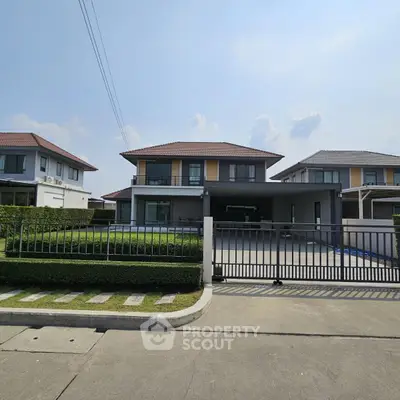 Modern two-story house with spacious driveway and manicured lawn in suburban neighborhood.