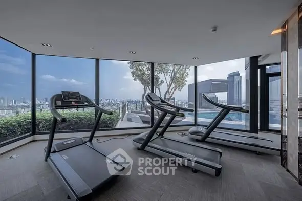 Luxury gym with panoramic city view and modern treadmills