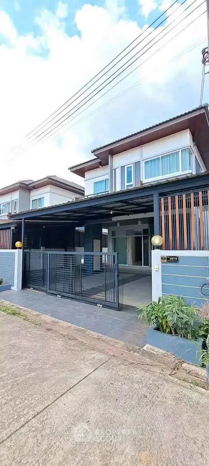 Modern two-story house with sleek design and spacious driveway in a suburban neighborhood.