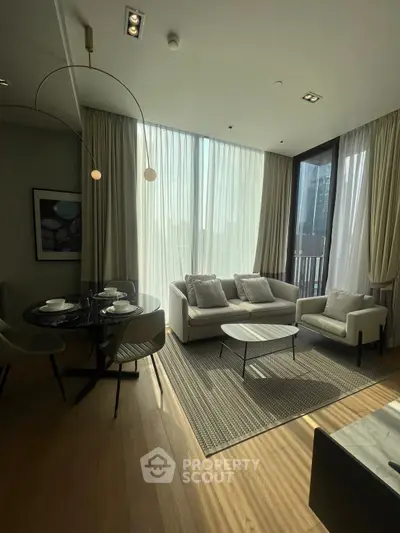 Modern living room with elegant furniture and large windows offering natural light and city views.
