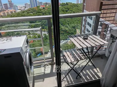 Charming balcony with city view, featuring a compact table and washing machine, perfect for urban living.